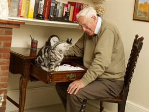 Gentleman with his cat at a writing desk