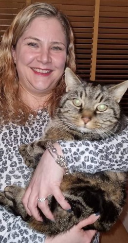 blonde long-haired woman holding brown tabby cat