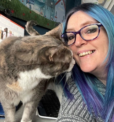 selfie of woman with long blue and purple dyed hair and glasses next to grey tortoiseshell cat