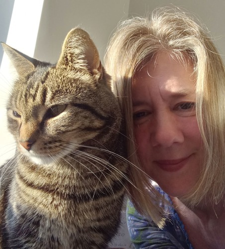 selfie of woman with short blonde hair next to brown tabby cat