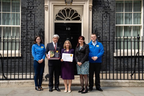 Three women and two men standing outside No 10 Downing Street holding box of letters for the Prime Minister