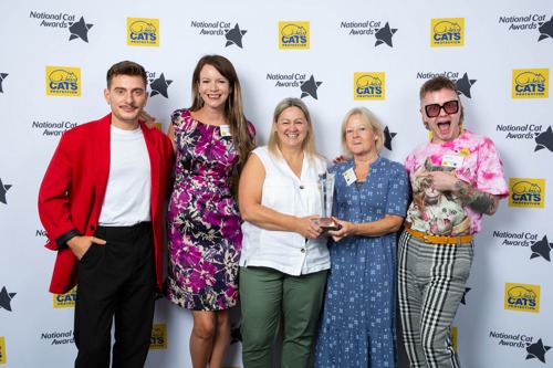 five people standing in front of National Cat Awards 2022 backdrop