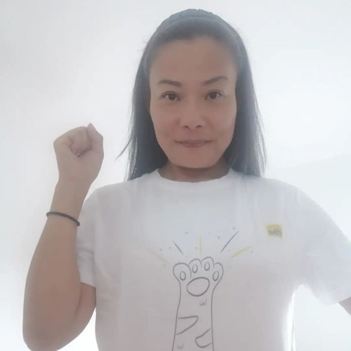 woman with long brown hair holding fist in the air and wearing white t-shirt with cat paw design