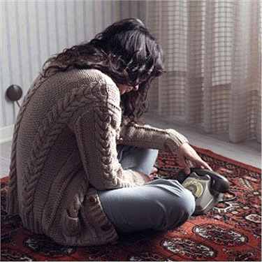 Woman sitting on the floor looking at a phone