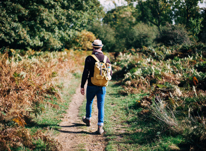 man wearing backpack walking along a path