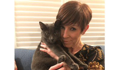brunette woman holding grey cat