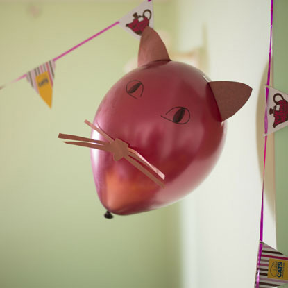 pink balloon with cat ears, eyes and whiskers