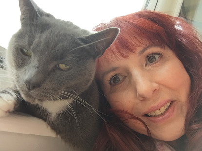 grey and white cat with red-haired woman