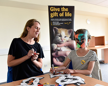 girl decorating cat face mask