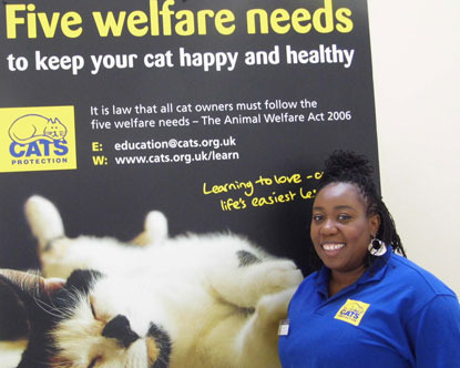 Chizzy Akudolu in front of a Cats Protection poster