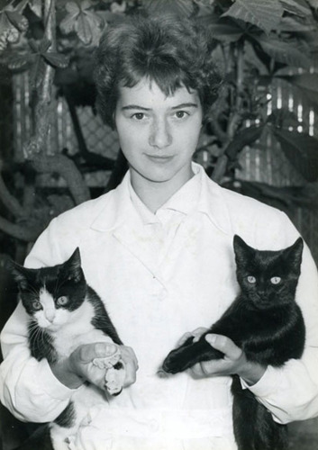 woman holding two cats in black and white historic photo
