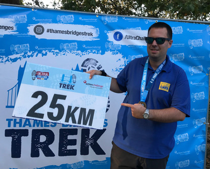 man holding 25km sign at race finish line