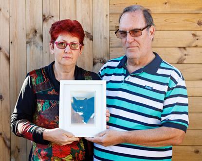 woman and man holding photo of their cat