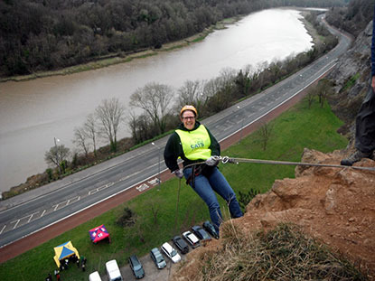 woman abseiling in Cats Protection vest