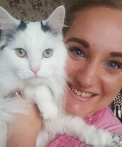 woman holding longhaired white and black cat