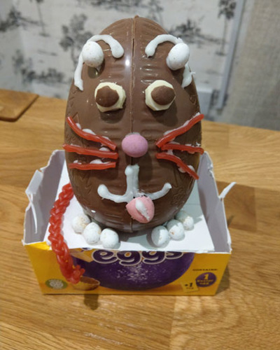 chocolate Easter egg decorated like a cat face