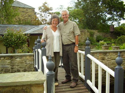 man and woman couple standing on small bridge