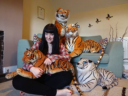 black-haired woman with cuddly toy tigers