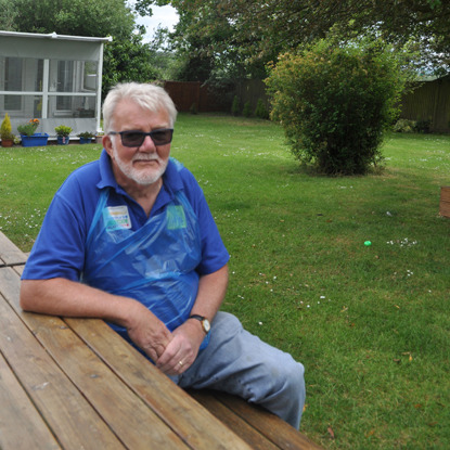 man in Cats Protection t-shirt sitting at a bench