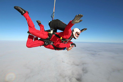 woman and man doing tandem skydive above clouds