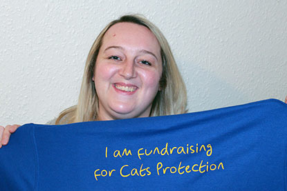 blonde woman holding t-shirt that says I am fundraising for Cats Protection