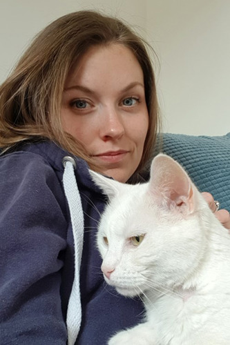 blonde woman hugging white cat