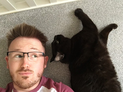 man lying on the floor next to black cat