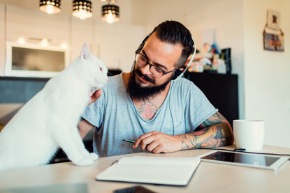 white cat and man with beard sitting at desk