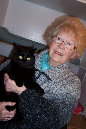 older woman holding black cat