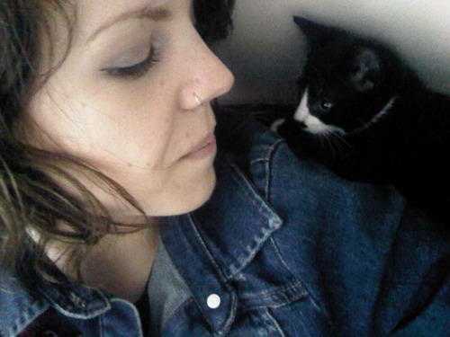 woman with black kitten sitting on her shoulder
