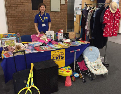 woman at Cats Protection stall selling clothing, toys and books