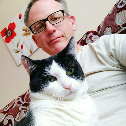 selfie of man with black and white cat on his lap