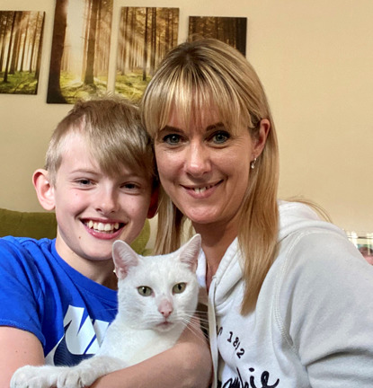 blonde boy and blonde woman holding white cat
