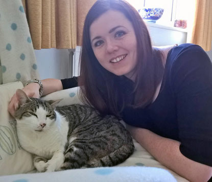 lady stroking tabby and white cat