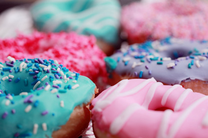 ring doughnuts covered in colourful icing and sprinkles