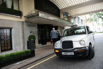 white taxi outside The Savoy hotel entrance