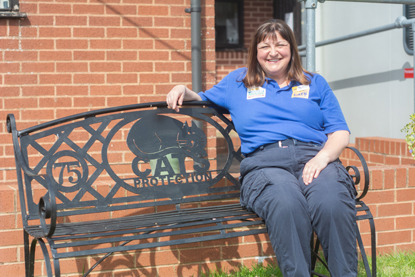 Woman sitting on Cats Protection bench