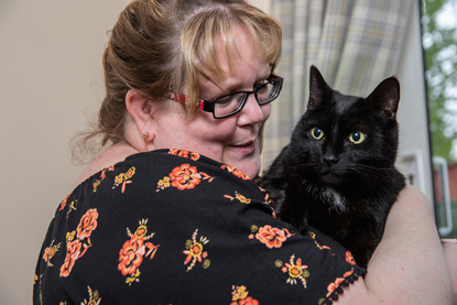 blonde woman holding black cat