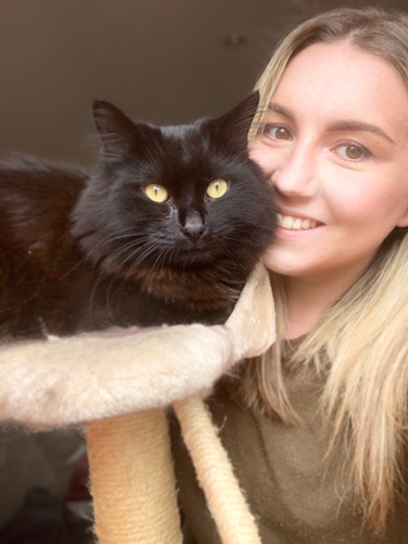 blonde woman with long-haired black cat