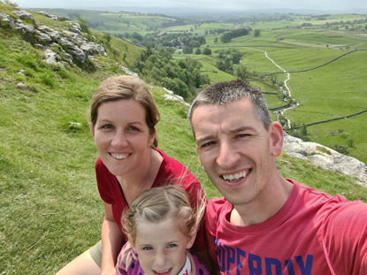 a family sitting on a hill side