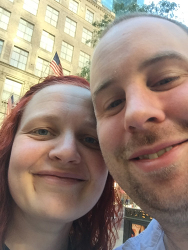 close up selfie of red-headed woman and short-haired man