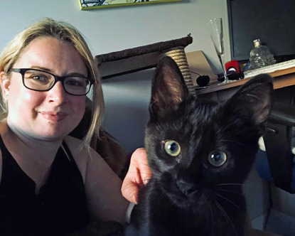 blonde woman wearing glasses with black cat