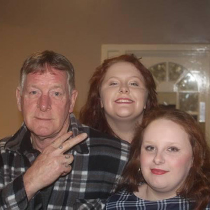 grey-haired man with two red-haired women