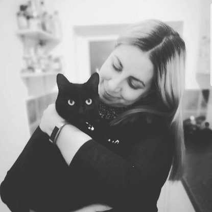 black and white photo of woman holding black cat