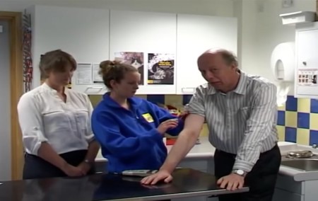 Cats Protection staff putting a microchip in a man's arm