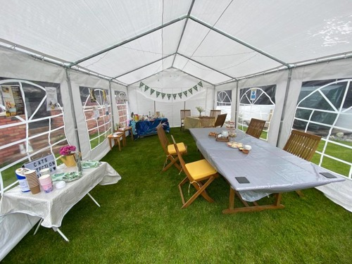 A white marquee on grass with tables inside