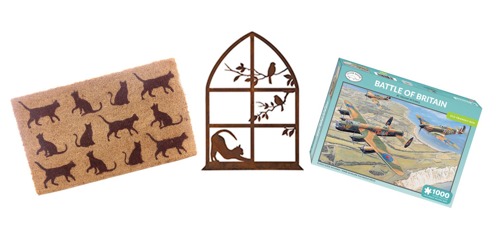 A doormat with cats on, a cast iron wall hanging featuring a cat stretching in a window frame and a Battle of Britain jigsaw puzzle box