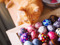 Ginger cat sniffing some colourful painted eggs 