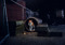 ginger-and-white cat stood inside a large pipe outdoors in the dark