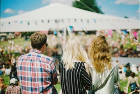 A man and two women outside at an event